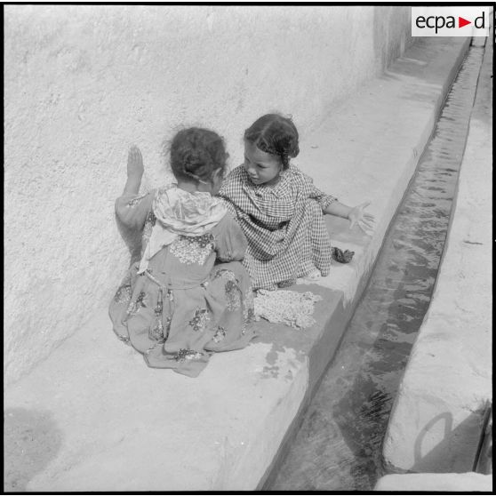 Les enfants, faisant la lessive à l'eau courante.