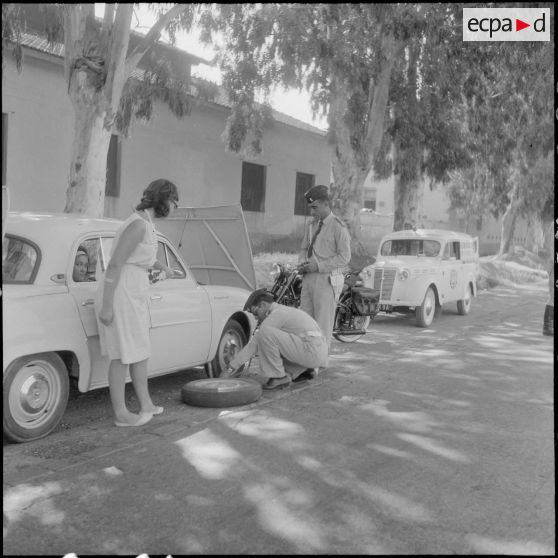 Une jeune femme en panne reçoit de l'aide de la part du secours routier.