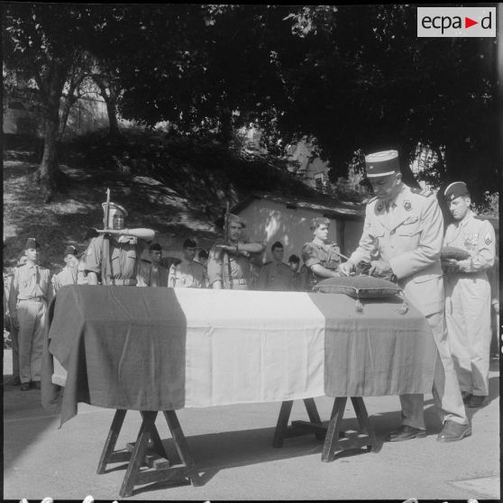 Un lieutenant-colonel, remettant la rosette de la Légion d'honneur et la Croix de la Valeur militaire à titre posthume.