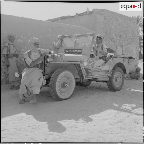 Bir el Adal. Cérémonie de l'échange des montures. Des méharistes à bord d'une jeep de gendarmerie.