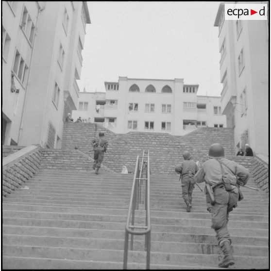Alger. Climat de France. Des soldats montent un escalier dans la rue.