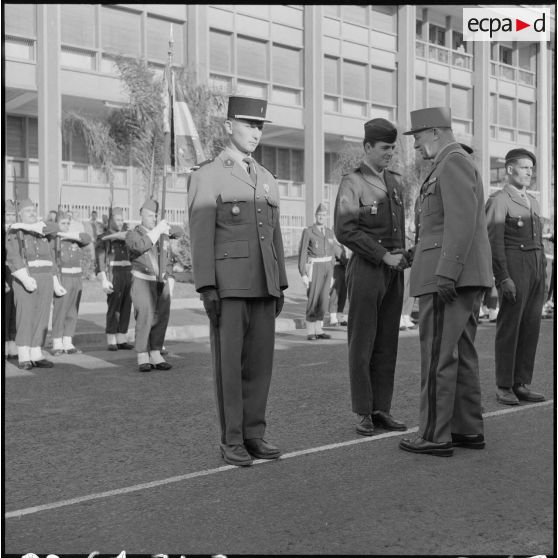 Alger. Cérémonie du 11 Novembre 1961. Une autorité militaire serre la main d'un soldat.