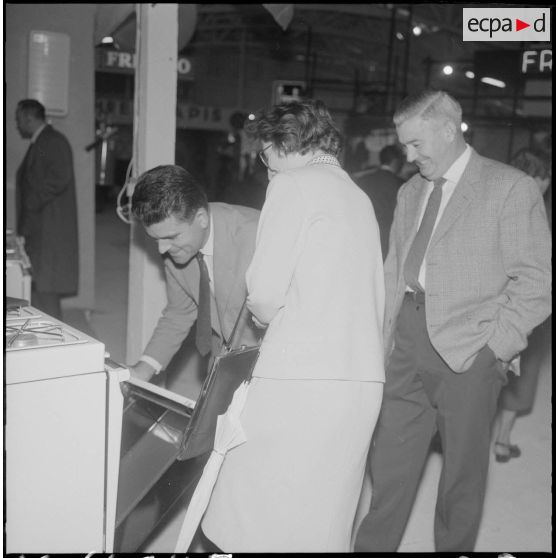 Alger. Exposition d'électroménager. Divers visiteurs, devant les stands de machines de cuisine.