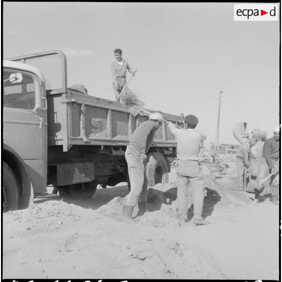 Sidi Salem. Les ouvriers chargent 'un camion.