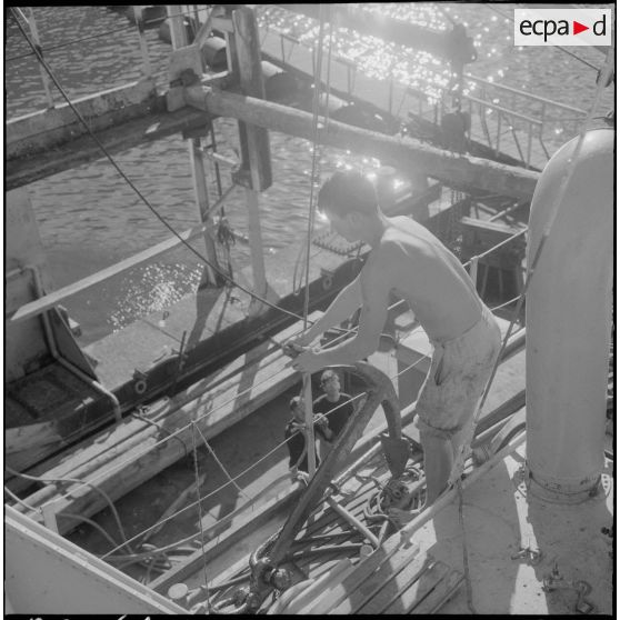 Mers el-Kébir. Les membres de l'équipage, pour la plupart marins appelés, hissent l'ancre à bord de la vedette côtière P755.