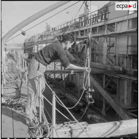 Mers el-Kébir. Les membres de l'équipage, pour la plupart marins appelés, hissent l'ancre à bord de la vedette côtière P755.