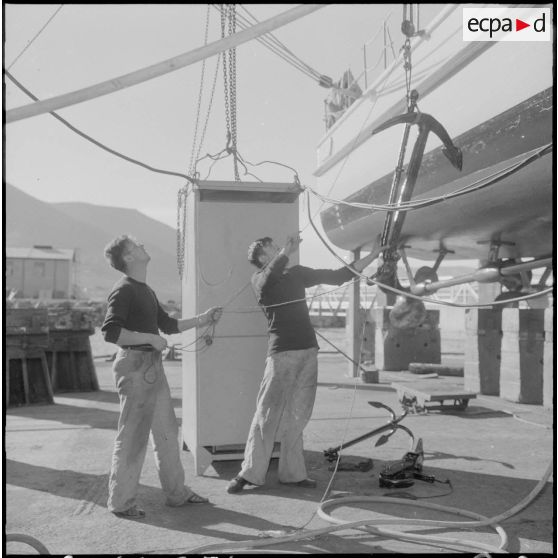 Mers el-Kébir. Les membres de l'équipage, pour la plupart marins appelés, hissent l'ancre à bord de la vedette côtière P755.