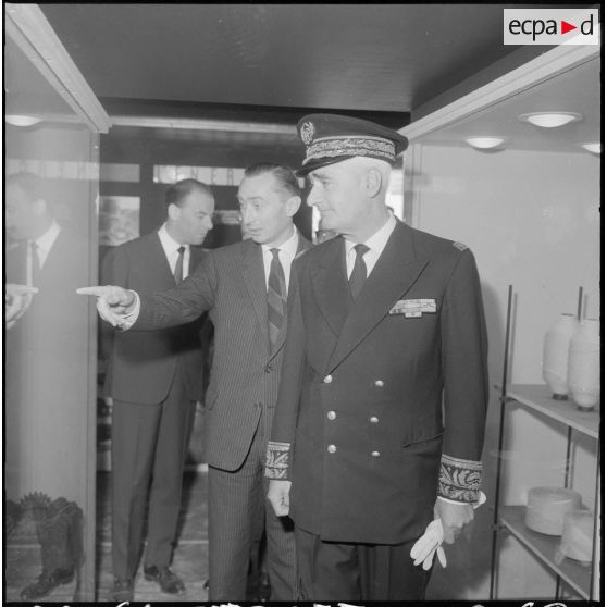 Inauguration de la foire exposition d'Oran. Pendant la visite monsieur Andrieu écoute les explications de son guide monsieur Le Portz.
