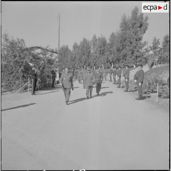 Beni Messous. Prise d'armes au 411e régiment d'artillerie antiaérien (RAA). Le général Ailleret marche en tête des autorités.