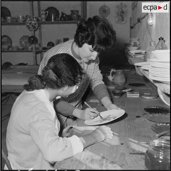 Rio Salado. Atelier de céramique. La monitrice montre l'emploi des couleurs à son élève.