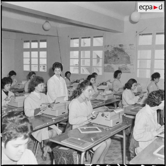 Oran. Centre féminin de formation professionnelle pour adulte. Le professeur de sténo-dactylo passe dans les rangs pour corriger les élèves.