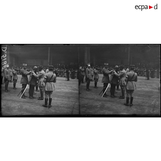Paris, au grand palais. Remise de décorations par le général Dubail, le général Dubail donne l'accolade à un général qu'il vient de décorer. [légende d'origine]