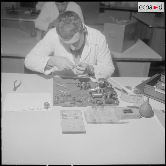 Camp de L'Alma (camp Bonvalot). Centre d'instruction du service du matériel n°3 (CISM n° 3). Un soldat travaillant sur des pièces en cours d'optique.