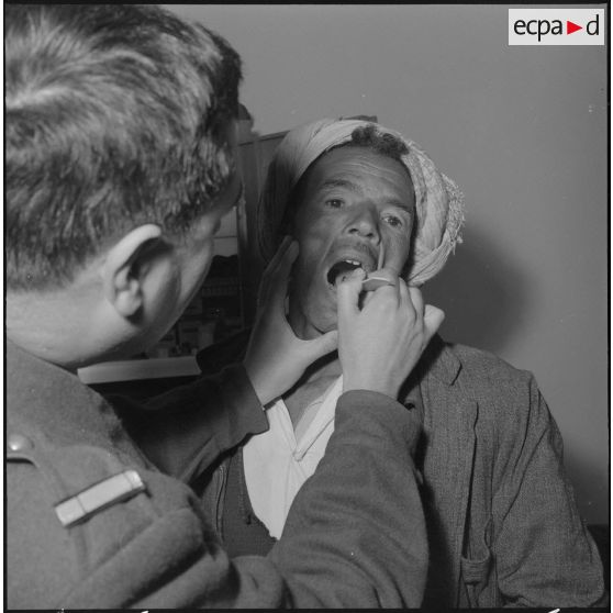 Aïn Temouchent. Le médecin aspirant regarde la gorge d'un malade.