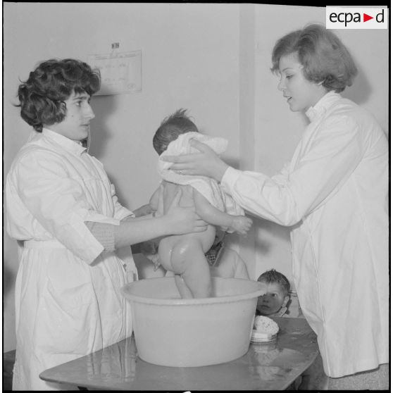 Aïn Temouchent. Une membre de l'équipe médico-sociale itinérante montre à une mère comment faire la toilette de son bébé.