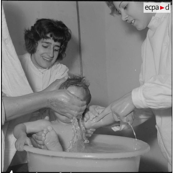 Aïn Temouchent. Une membre de l'équipe médico-sociale itinérante montre à une mère comment faire la toilette de son bébé.