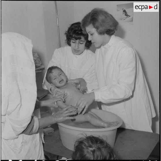 Aïn Temouchent. Une membre de l'équipe médico-sociale itinérante montre à une mère comment faire la toilette de son bébé.
