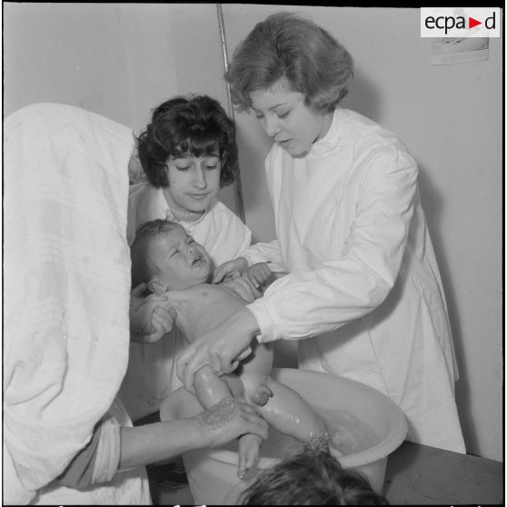 Aïn Temouchent. Une membre de l'équipe médico-sociale itinérante montre à une mère comment faire la toilette de son bébé.