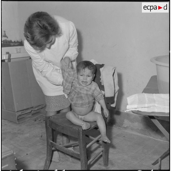 Aïn Temouchent. Une membre de l'équipe médico-sociale itinérante montre à une mère comment faire la toilette de son bébé.