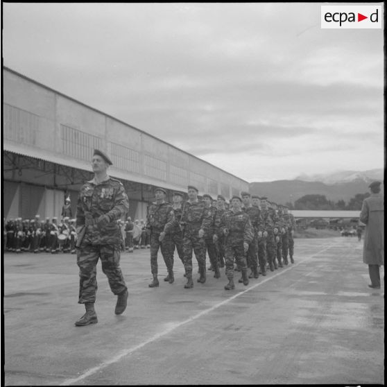 Boufarik. Prise d'armes et remise de décoration. Une section de parachutiste passe devant le général Picquet et les officiers.