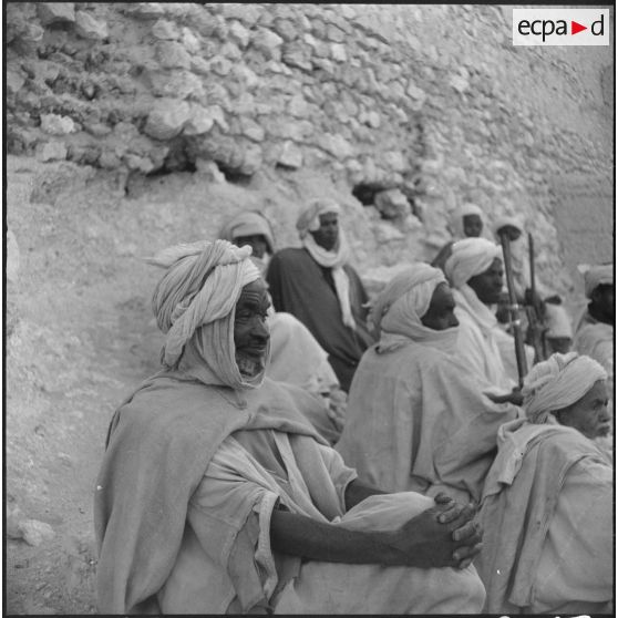 Charouine. Fête de la population civile. Des hommes écoutent et regardent les musiciens.