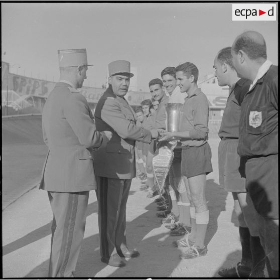 Stade municipal d'Alger. Finale des championnats interarmées de football. Le général Rafa remet la coupe au capitaine de l'équipe du 9e régiment de zouaves (RZ).