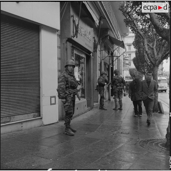 Alger. Quadrillage avant le cessez-le-feu. Des soldats et des passants dans la rue.