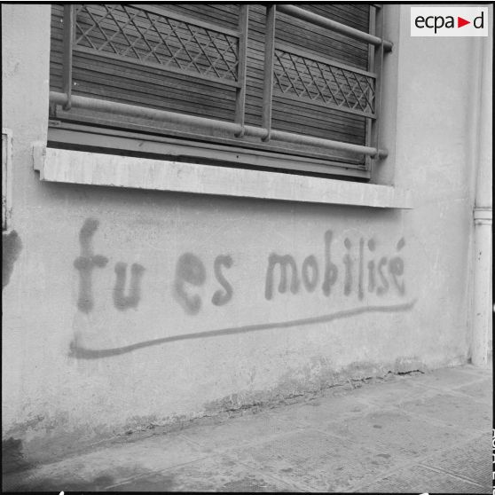 Alger. Quadrillage avant le cessez-le-feu. Slogan "Tu es mobilisé" écrit sur un mur.