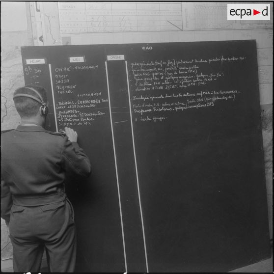 La Reghaïa. Salle opérationnelle des transmissions. Un soldat note des renseignements sur un tableau.
