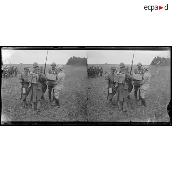 Près de Mareuil, Oise. Prise d'armes pour la remise de décorations. Après la revue, le chef d'Etat major distribue du tabac aux soldats. [légende d'origine]