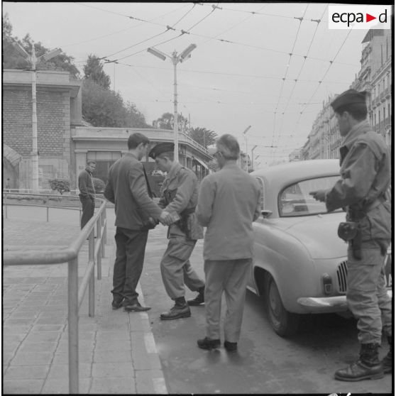 Alger. Grève générale à l'appel de l'Organisation armée secrète (OAS). Une patrouille fouille un homme en Renault Dauphine, place Lyautey.