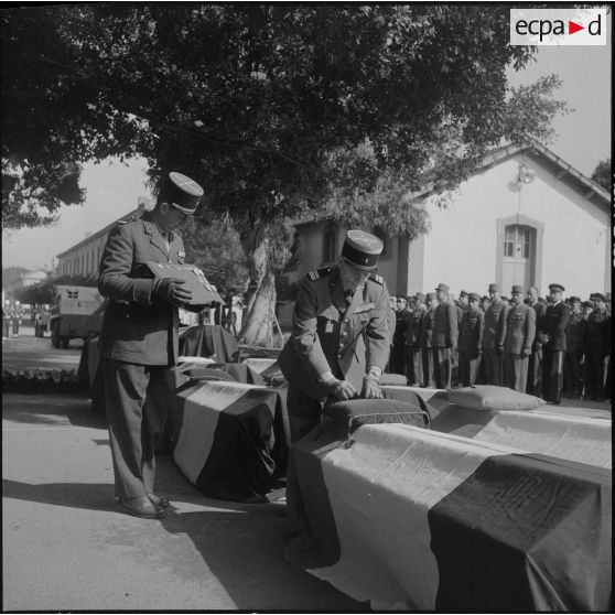 Alger. Chapelle de l'hôpital Maillot. Obsèques des militaires tués à Bab el Oued lors de la fusillade du 23 mars 1962. Une autorité remet une décoration à titre posthume.