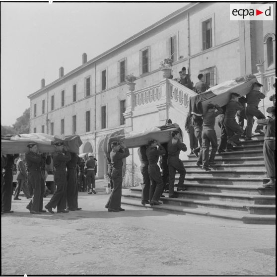 Alger. Chapelle de l'hôpital Maillot. Obsèques des militaires tués à Bab el Oued lors de la fusillade du 23 mars 1962. Des soldats portent les cerceuils à la chapelle.