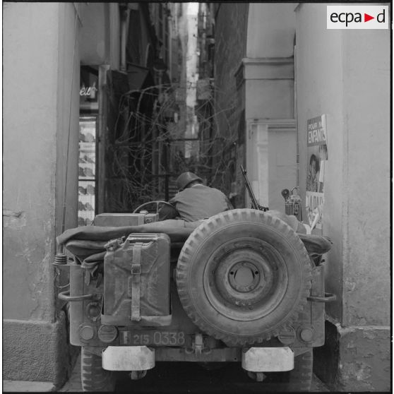 Alger. Journée de deuil du 27 mars 1962. Un soldat à bord d'une jeep devant un barrage de barbelés.