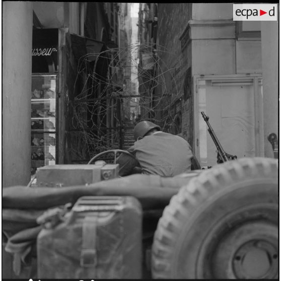 Alger. Journée de deuil du 27 mars 1962. Un soldat à bord d'une jeep devant un barrage de barbelés.