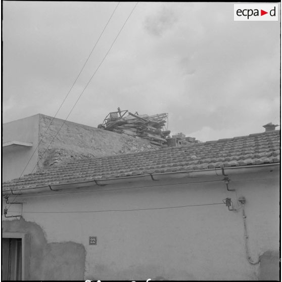 Oran. Fouilles et récupérations d'armes de l'Organisation armée secrète (OAS). Un gendarme mobile fouille le toit d'une maison.