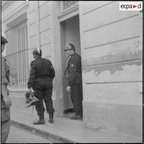 Oran. Fouilles et récupérations d'armes de l'Organisation armée secrète (OAS). Deux gendarmes mobiles fouillent un immeuble.