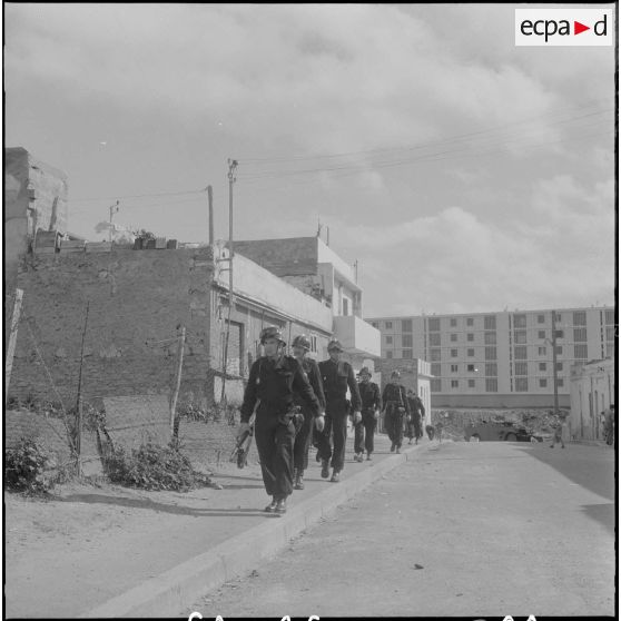 Oran. Fouilles et récupérations d'armes de l'Organisation armée secrète (OAS). Des gendarmes mobiles en patrouille dans une rue.