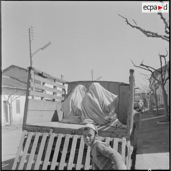 Fondouk. Deux femmes à l'arrière d'un camion avec un enfant au premier plan.