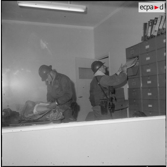 Oran. Des soldats fouillent un bureau.