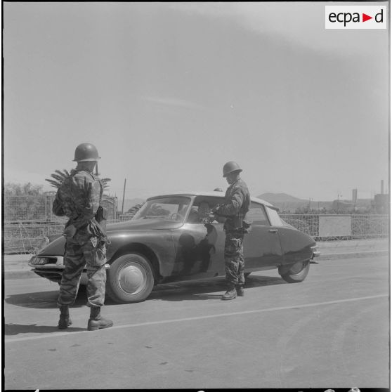 Bouclage du centre d'Oran. Un soldat s'adresse à un homme en voiture Citroën DS.