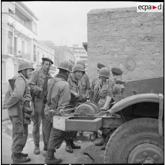 Oran. Bouclage de la ville. Le caméraman de l'Etablissement cinématographique des armée (ECA) Gérard Py entouré de soldats.