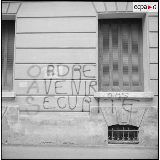 Oran. Slogan "Ordre Avenir Sécurité" de l'Organisation armée secrète (OAS) écrit sur un mur.