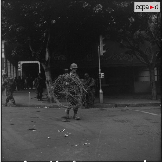 Bouclage d'Oran. Un soldat transporte des barbelés.