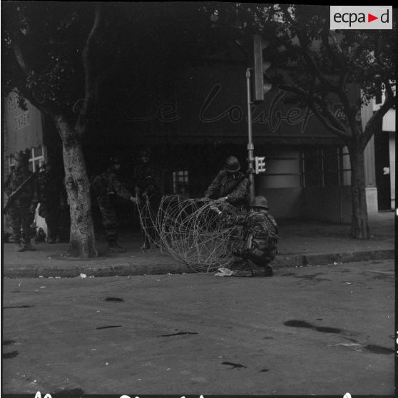 Bouclage d'Oran. Des soldats installent les barbelés dans une rue.
