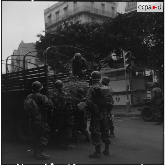Bouclage d'Oran. Des soldats descendent des barbelés d'un camion.