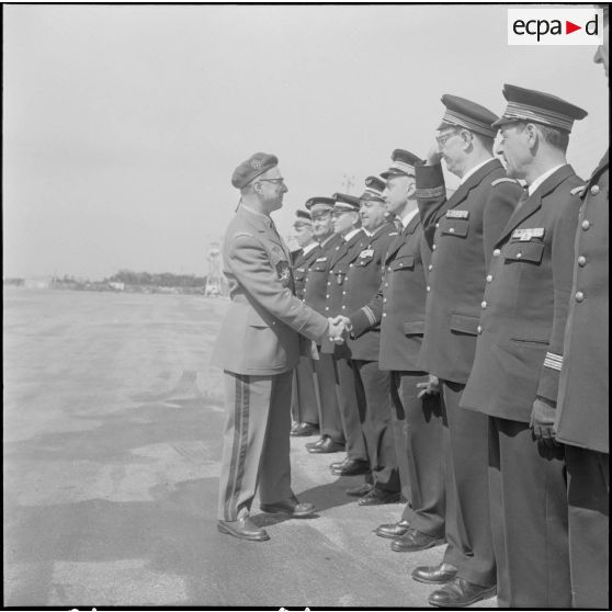 Une base aérienne en Algérie. Départ du général Ailleret. Le général serre la main d'un officier.