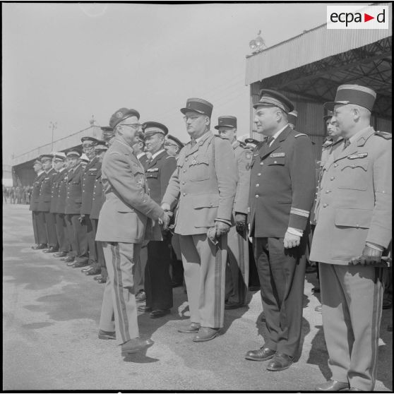 Une base aérienne en Algérie. Départ du général Ailleret. Le général serre la main d'un officier.