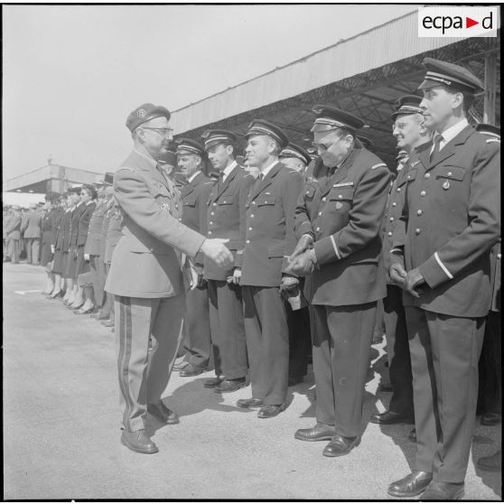 Une base aérienne en Algérie. Départ du général Ailleret. Le général serre la main d'un officier.