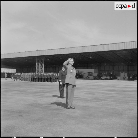 Une base aérienne en Algérie. Départ du général Ailleret. Le général salue pendant la cérémonie.